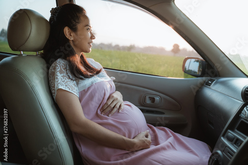 asian pregnant woman enjoy the car trip while sitting on passanger seat © Odua Images
