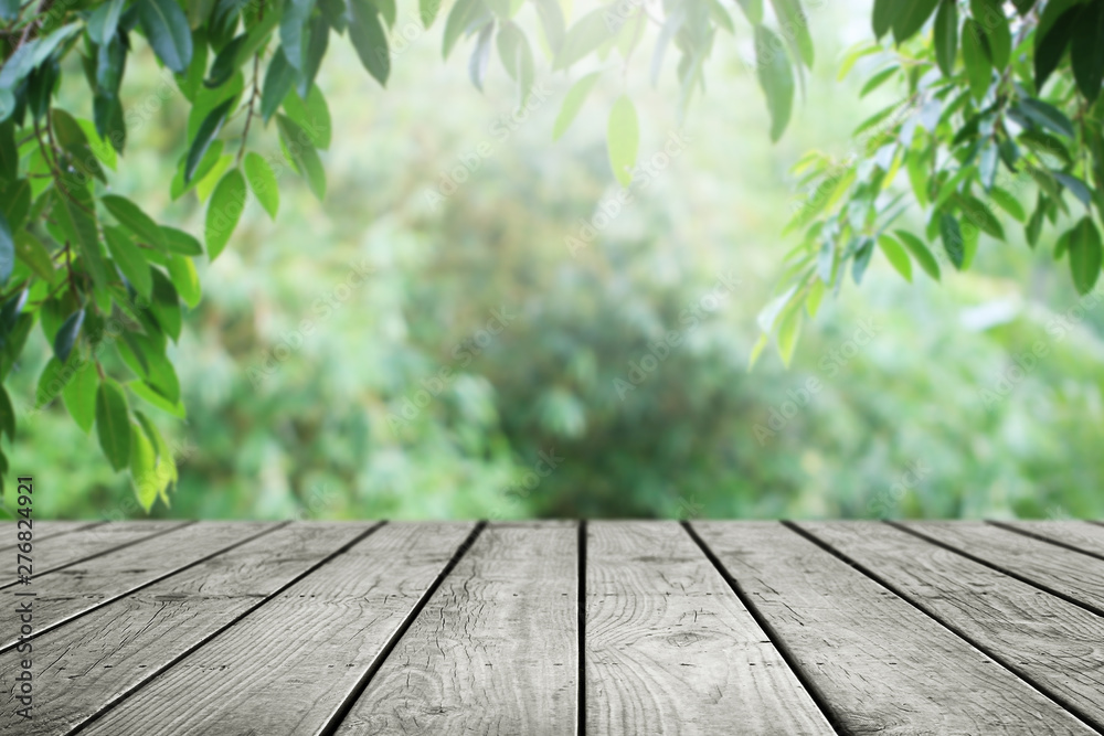 Wooden table and blurred green leaf nature in garden background.  - obrazy, fototapety, plakaty 