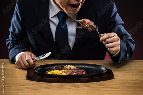 ステーキを食べるビジネスマン photo