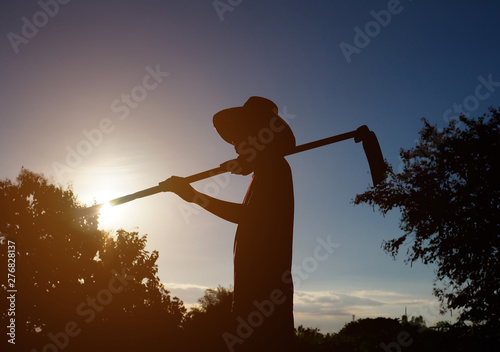 Silhouette of a farmer with sunset in nature landscape