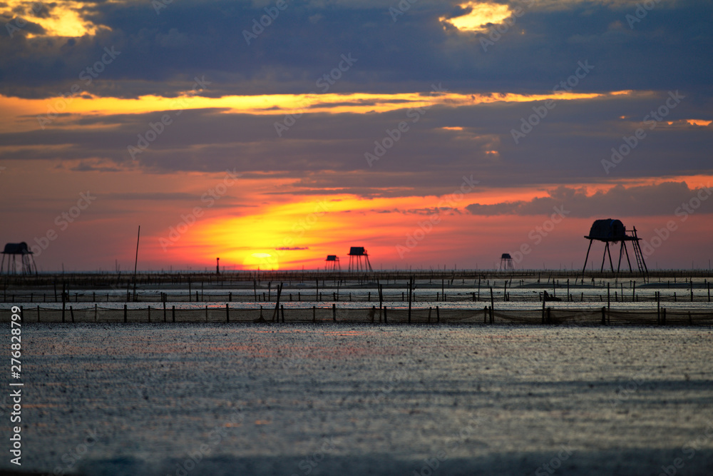 Sunrise over clam farms on Dong Chau beach, Thai Binh, Vietnam