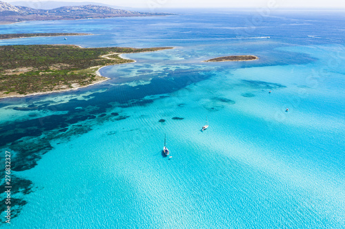 View from above, stunning aerial view of some boats sailing on a beautiful turquoise clear water. Spiaggia La Pelosa (Pelosa beach) Stintino, Sardinia, Italy. photo