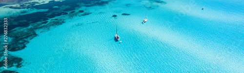 View from above, stunning aerial view of some boats sailing on a beautiful turquoise clear water. Spiaggia La Pelosa (Pelosa beach) Stintino, Sardinia, Italy.