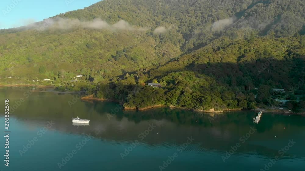 Sunrise aerial flying over sea and anchored boats towards bay and house on hill in Marlborough Sounds, New Zealand Sunrise aerial flying over sea and anchored boats towards bay and house on hill in Marlborough Sounds, New Zealand