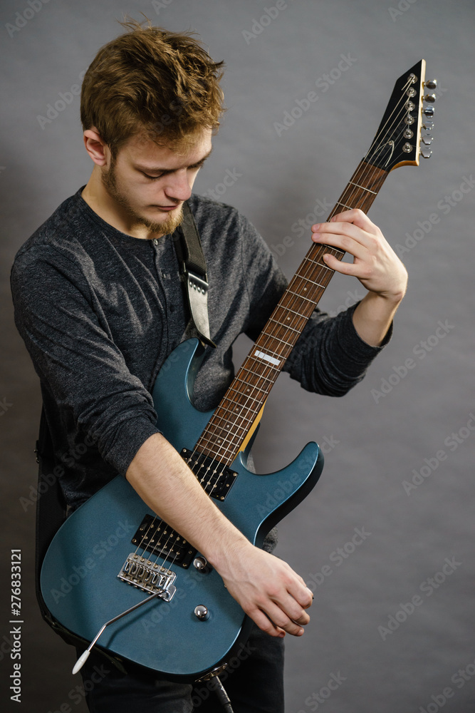 Young man playing electric guitar