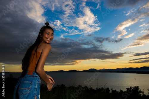 Open World Sky with wind Cloud over sunset red ray beam to adult asian woman long black hair skinny vast who feel lonely happy success to stand on top of clip ocean sight view, copy space low exposure