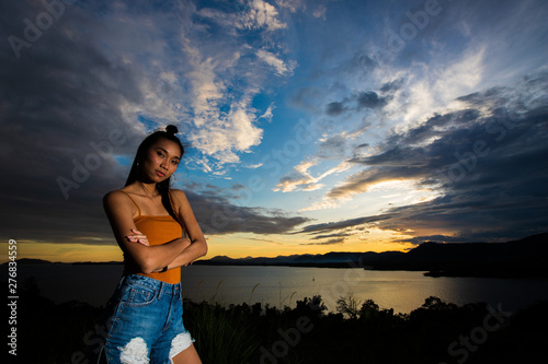 Open World Sky with wind Cloud over sunset red ray beam to adult asian woman long black hair skinny vast who feel lonely happy success to stand on top of clip ocean sight view  copy space low exposure