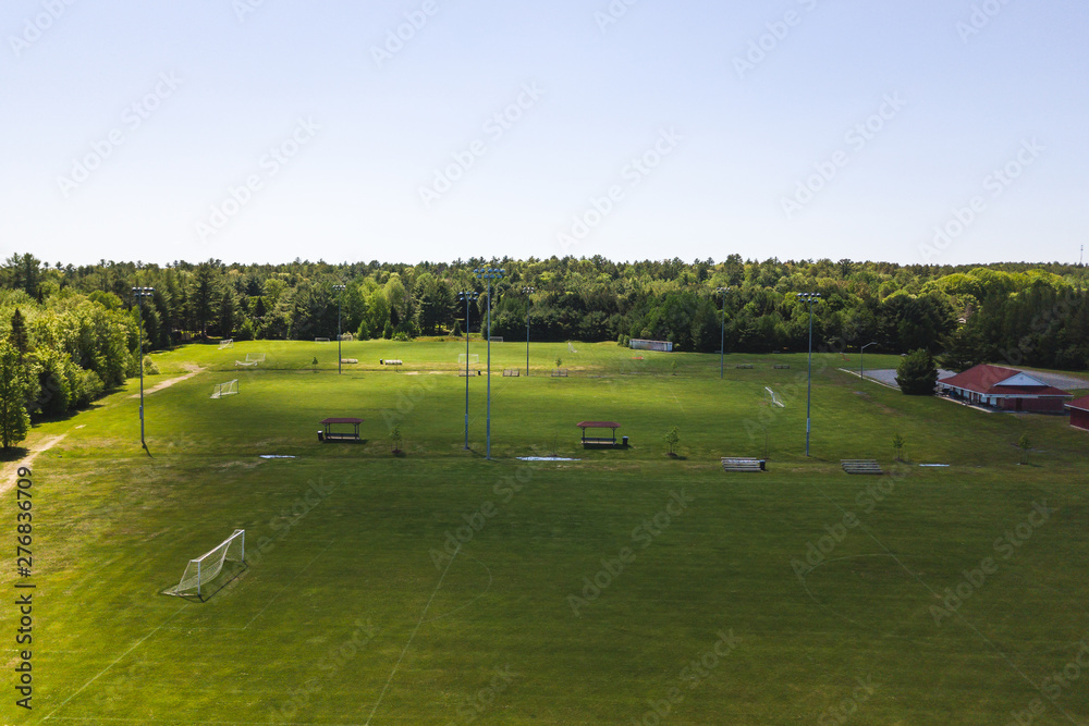 Aerial/Drone view of soccer/football field complex during the afternoon with shadows from clouds on the field in Ontario, Canada. Aerial/Drone view of soccer/football field complex during the afternoon with shadows from clouds on the field in Ontario, Canada.