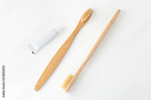 Wooden toothbrushes and toothpaste on white