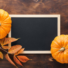 Fall chalkboard background with pumpkins, red and yellow leaves.