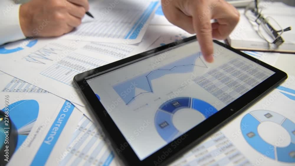 Businessman working with tablet pc, calculating, reading and writing reports. Office employee, table closeup. Business financial accounting concept.