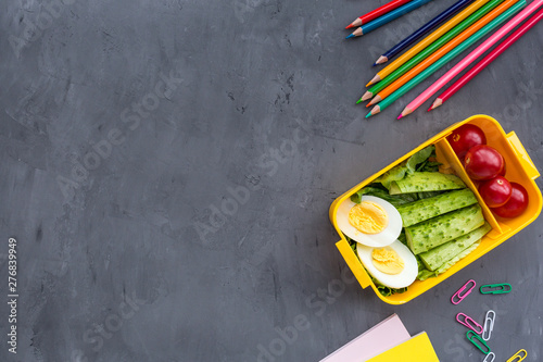 School supplies and lunch box with sandwich and vegetables. Back to school. Healthy eating habits concept - background layout with free text space. Flat lay composition, mockup, top view
