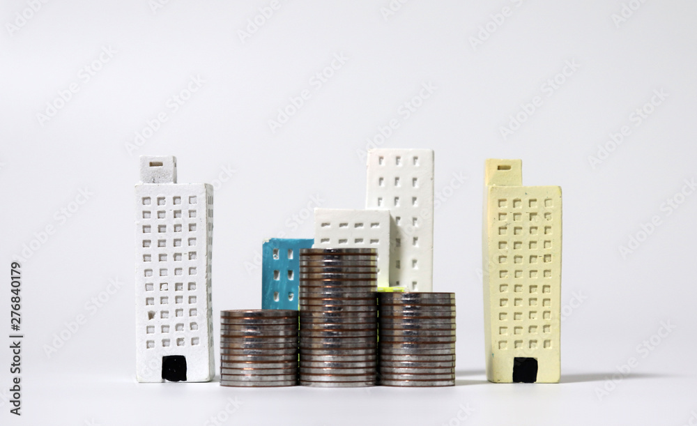 Miniature houses and piles of coins. Miniature houses and piles of coins.