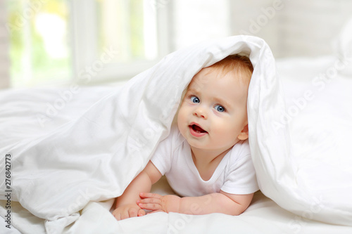 Принти на полотні Portrait of a charming blue-eyed baby 7 months in bed in white clothes