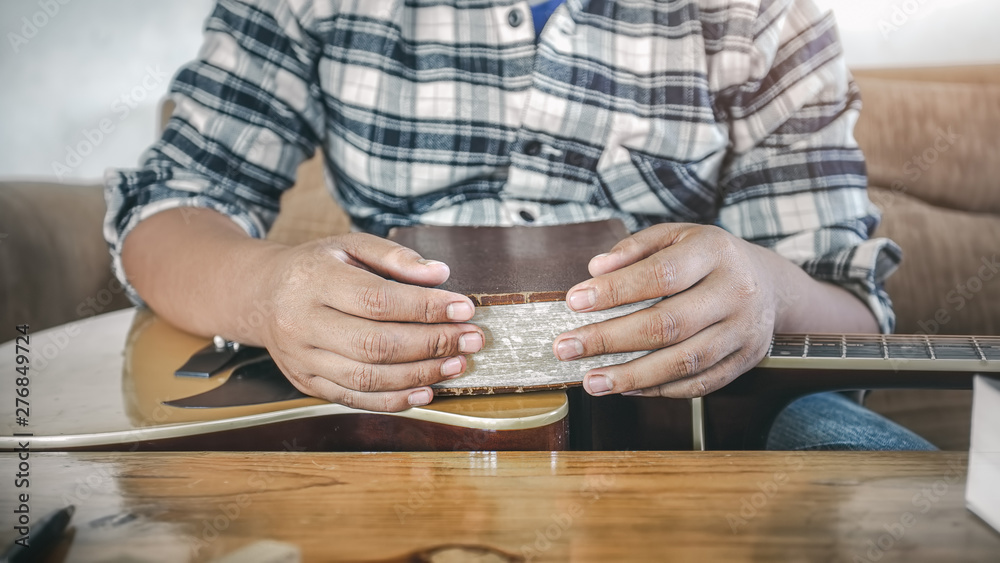 Close up hands of male praying and holding old Bible or book on guitar acoustic. Christian worship God concept. Close up hands of male praying and holding old Bible or book on guitar acoustic. Christian worship God concept.
