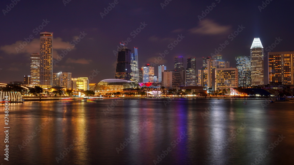 Skyline panorama of Singapore Downtown at night with Esplande and business buildings with offices. Views from Marina Bay.