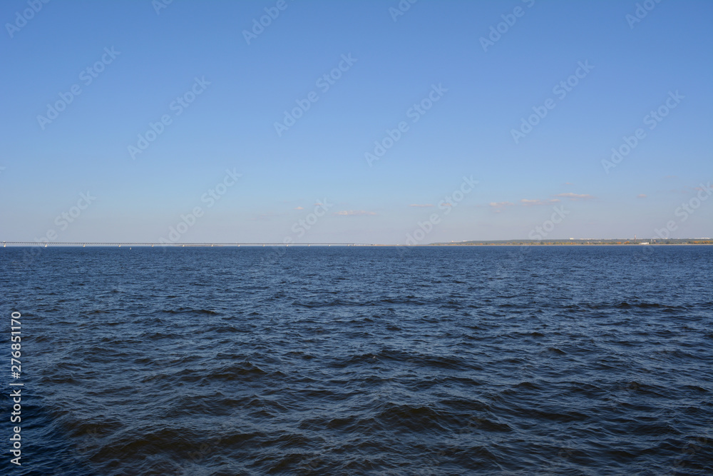 Landscape with blue sky and dark blue water of Volga river.