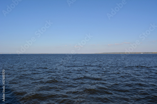 Landscape with blue sky and dark blue water of Volga river.