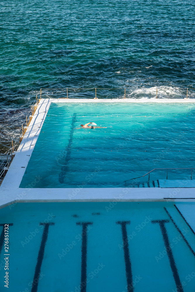 A Winter Swimmer isolated in ocean pool and last sunlight light of day