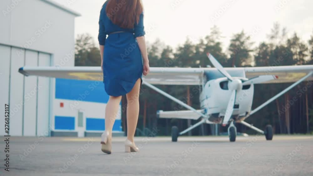Young woman coming to a light-engine private plane Young woman coming to a light-engine private plane