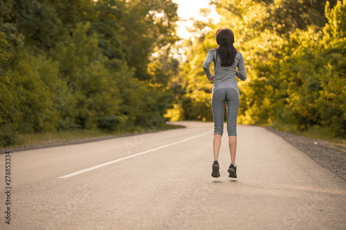 girl on a morning run. girl runs on the road. woman sport
