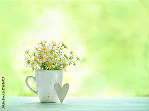 cute daisies in cup and heart, cozy rustic scene. summer season. chamomile flowers, gentle and pure nature. close up, copy space. soft selective focus