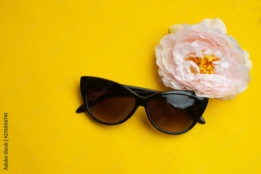 Woman sunglasses with flower on yellow background. Summer vacation concept. Face concept