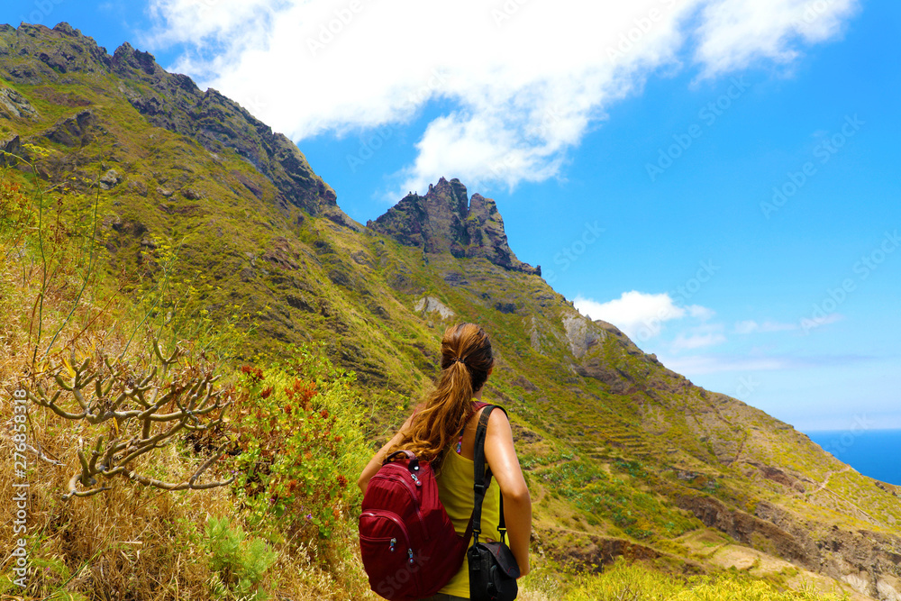 Naklejka premium Young hiker woman looking the peak of mountain thinking that much is needed to get to the top