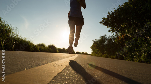 Fitness woman running on seaside trail in the morning