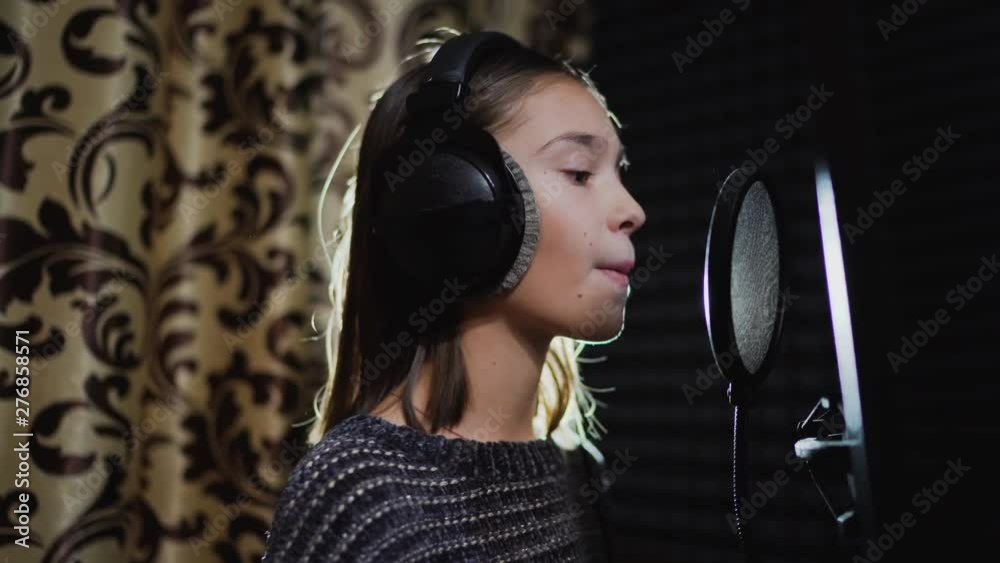 Singer child is training to make music in professional studio. Song production process. Talented kids. Track recording Singer child is training to make music in professional studio. Song production process. Talented kids. Track recording