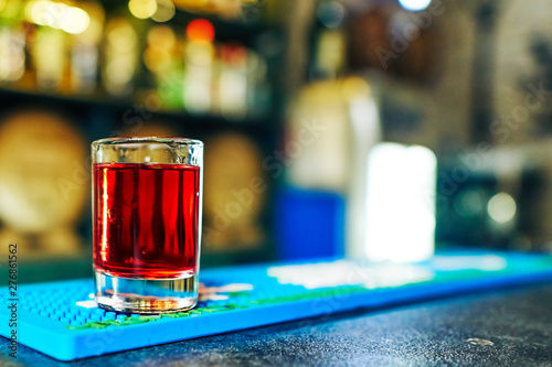 shot with a red drink on the background of the bar