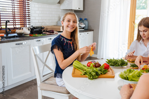 Pretty teenagers making a gamburger in the kitchen
