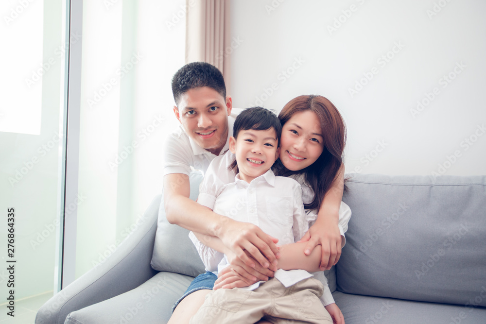 Happy Asian family with son at home on the sofa playing and laughing Happy Asian family with son at home on the sofa playing and laughing