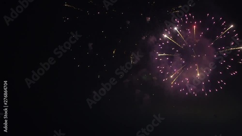 LOCKED OFF view of fireworks going off at night for party