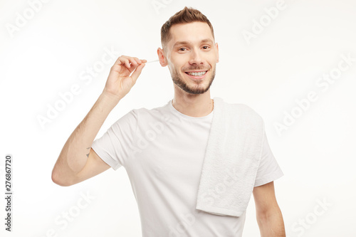 Smiling man cleans the ears with chopsticks