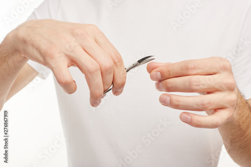 Closeup. Man cuts fingernails on a white background