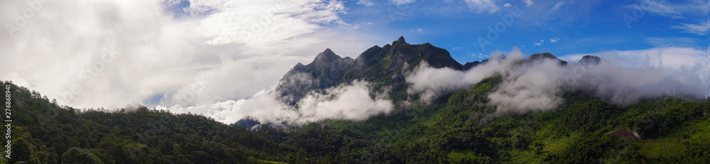 Panoramic. Green mountain scenery There is a mist in the mountains . The sky is blue and the clouds are white.