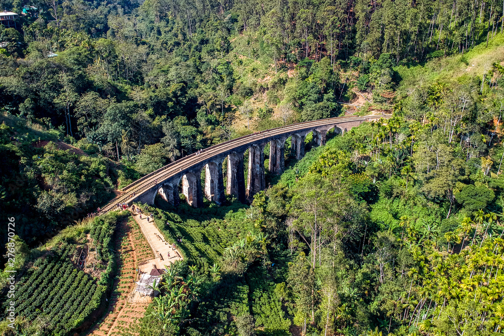 Aerial of famous nine arch bridge in Ella, Sri Lanka with blue train Aerial of famous nine arch bridge in Ella, Sri Lanka with blue train