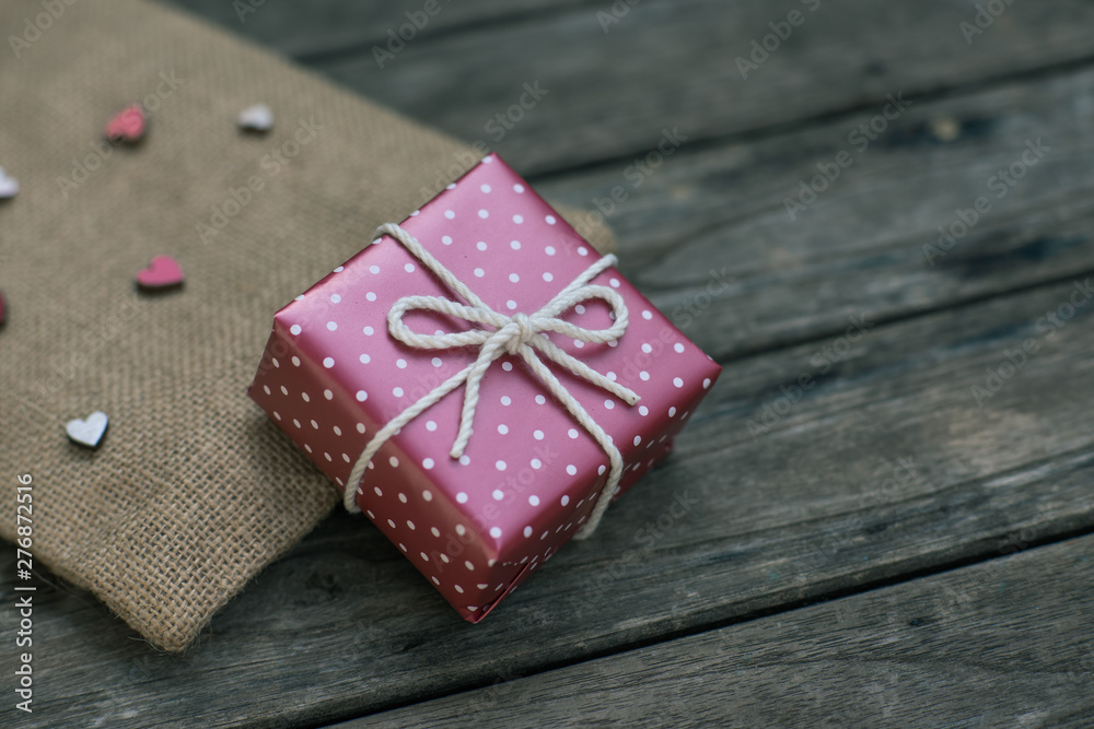 Red paper gift box tie with rope on old wooden background Red paper gift box tie with rope on old wooden background