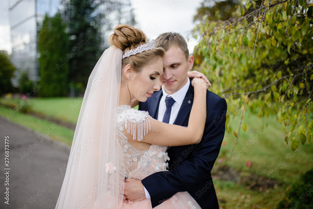 Bride and groom hug in the park. Close-up