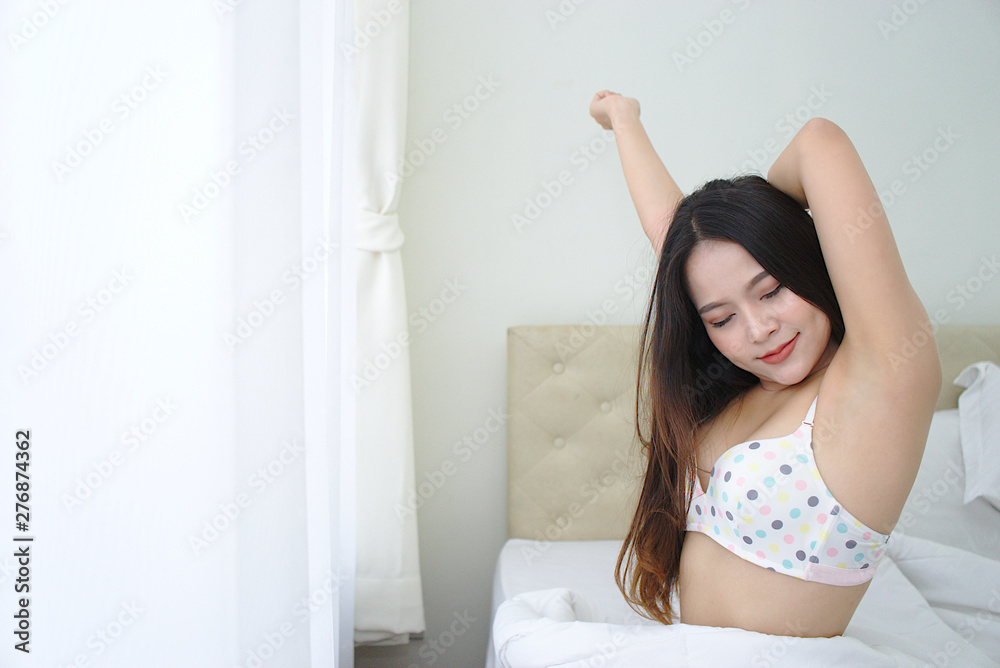 Asian beautiful woman waking up in the morning, a lot of lingerie. Sitting on the bed, smiling happily. Asian beautiful woman waking up in the morning, a lot of lingerie. Sitting on the bed, smiling happily.