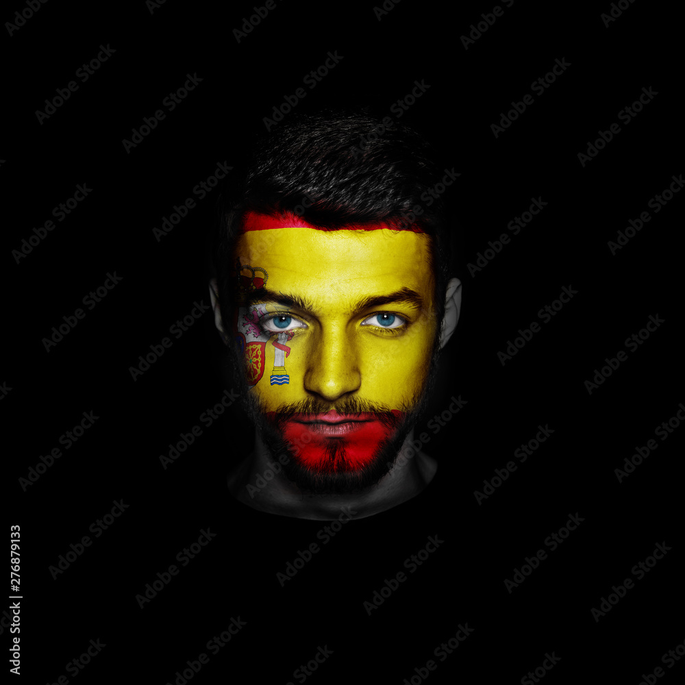 Flag of Spain painted on a face of a man on black background. Flag of Spain painted on a face of a man on black background.