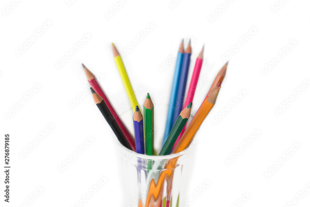 group of Multi-colored pencils in a transparent glass mug isolated on white