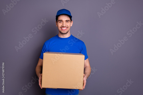 Close up photo express speed specialist he him his delivery boy hold strong arms large parcel box toothy come in time accept recipient wear blue t-shirt cap corporate suit isolated grey background photo