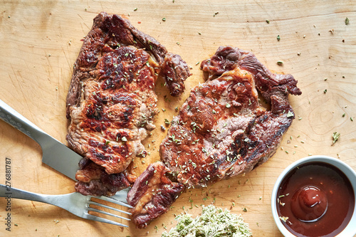 Bayerisches Dry Aged Steak gegrillt auf Holzbrett mit Oregano photo