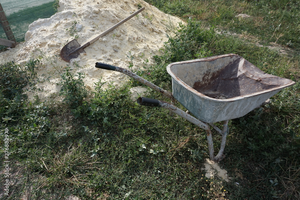 Construction truck and shovel next to a pile of sand. Construction truck and shovel next to a pile of sand.
