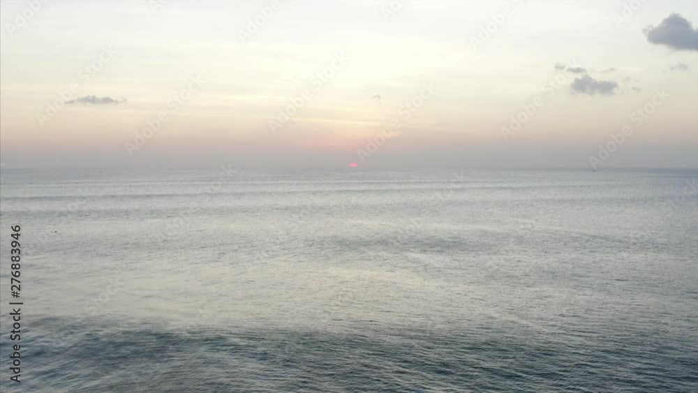 Beautiful peaceful landscape, aerial static view of endless ocean and red sun going down. Sunset. Bali, Indonesia Beautiful peaceful landscape, aerial static view of endless ocean and red sun going down. Sunset. Bali, Indonesia