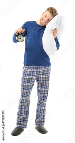 Sleepy man with pillow and alarm clock on white background