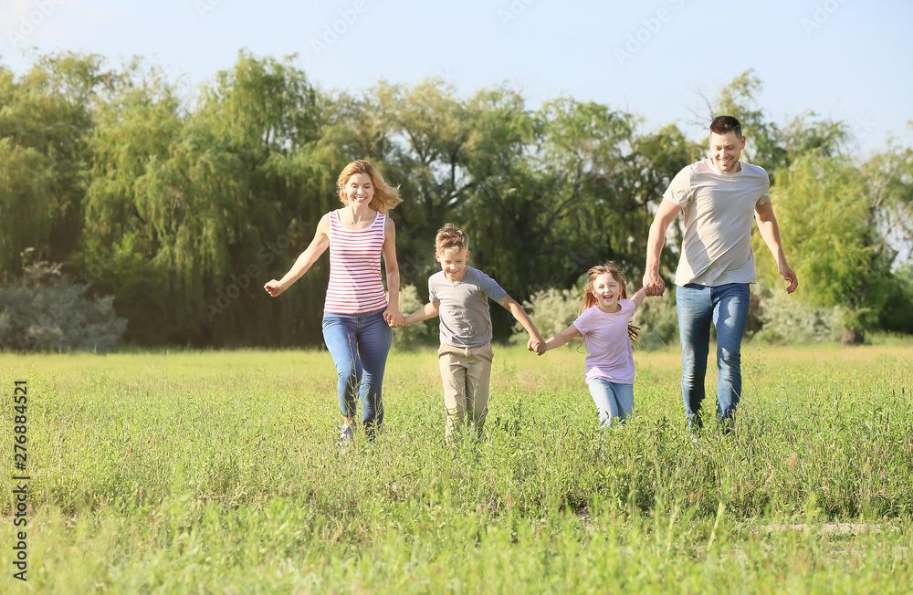 Happy family running in park on summer day Happy family running in park on summer day