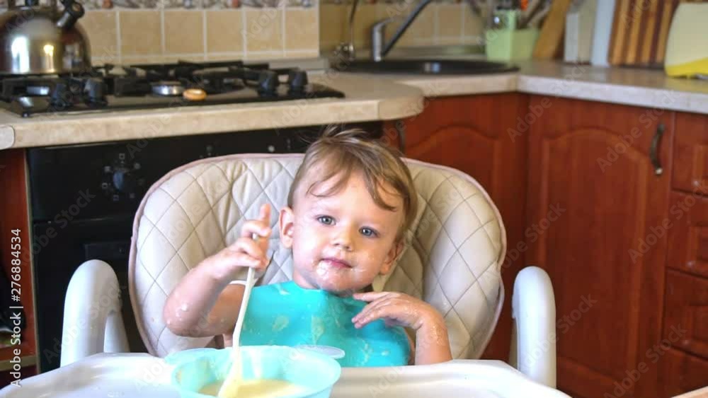 Little boy himself eats porridge soiled Little boy himself eats porridge soiled